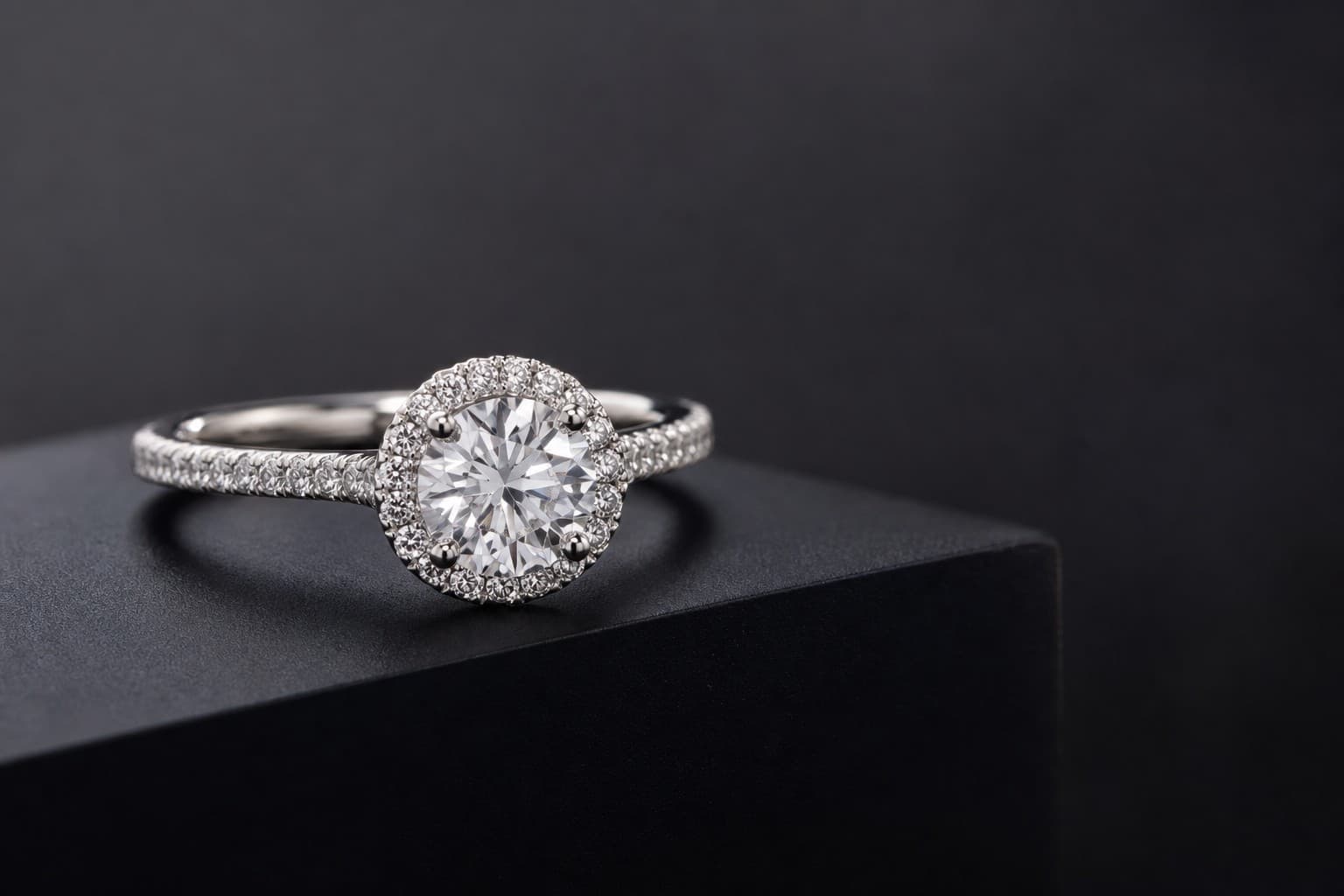 Close-up of an engagement ring displayed on a dark pedestal